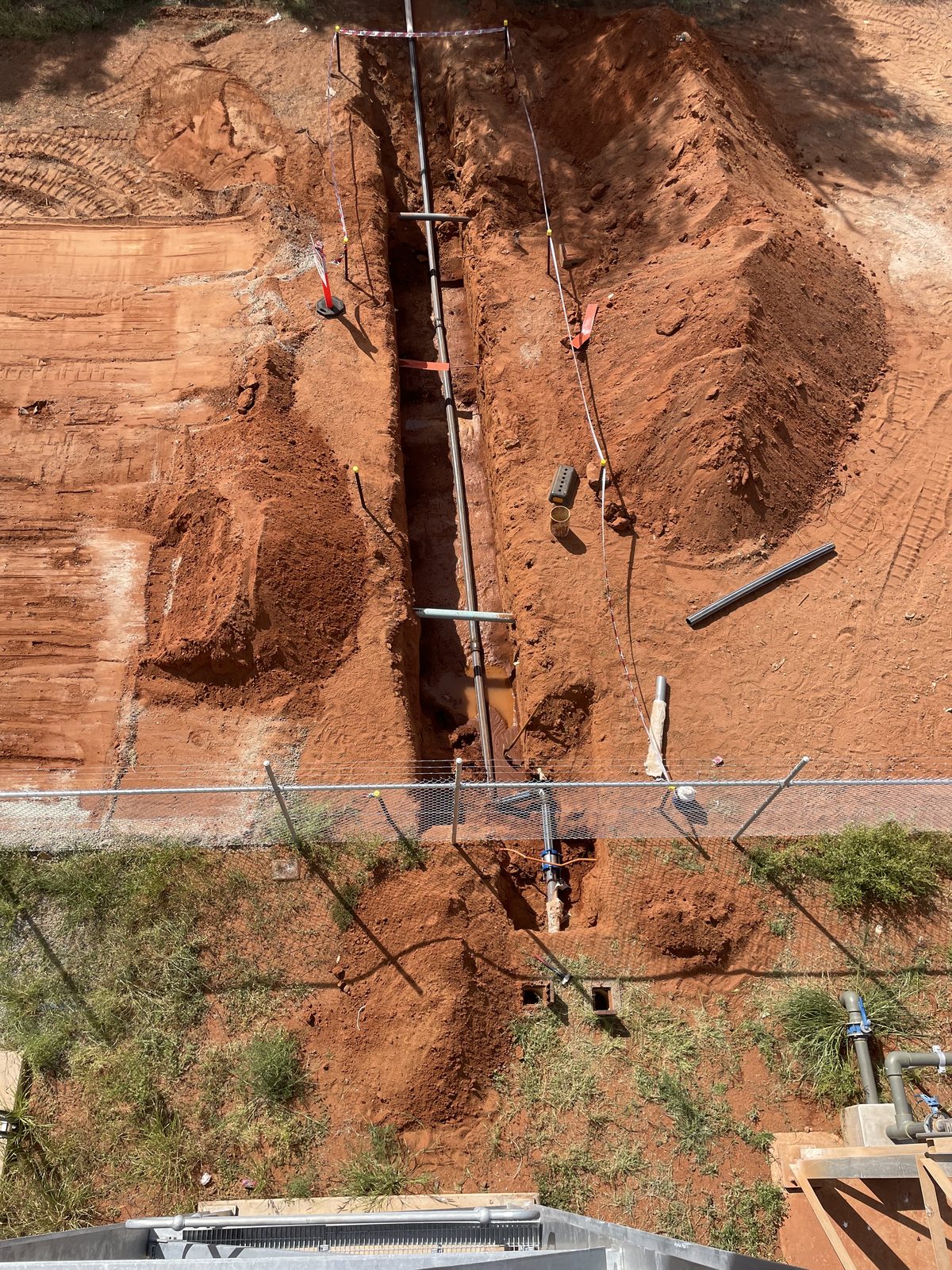 Aerial view of open trenching and pipe installation on a Pilbara site