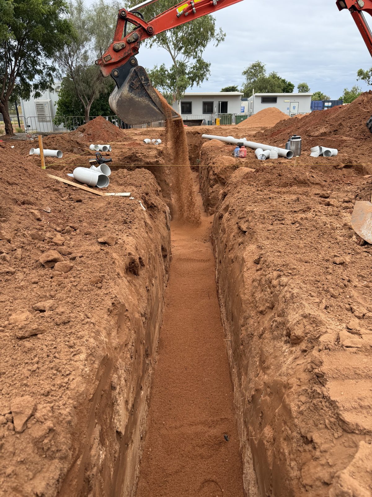 Sewer pipe laid on graded bedding in an open trench