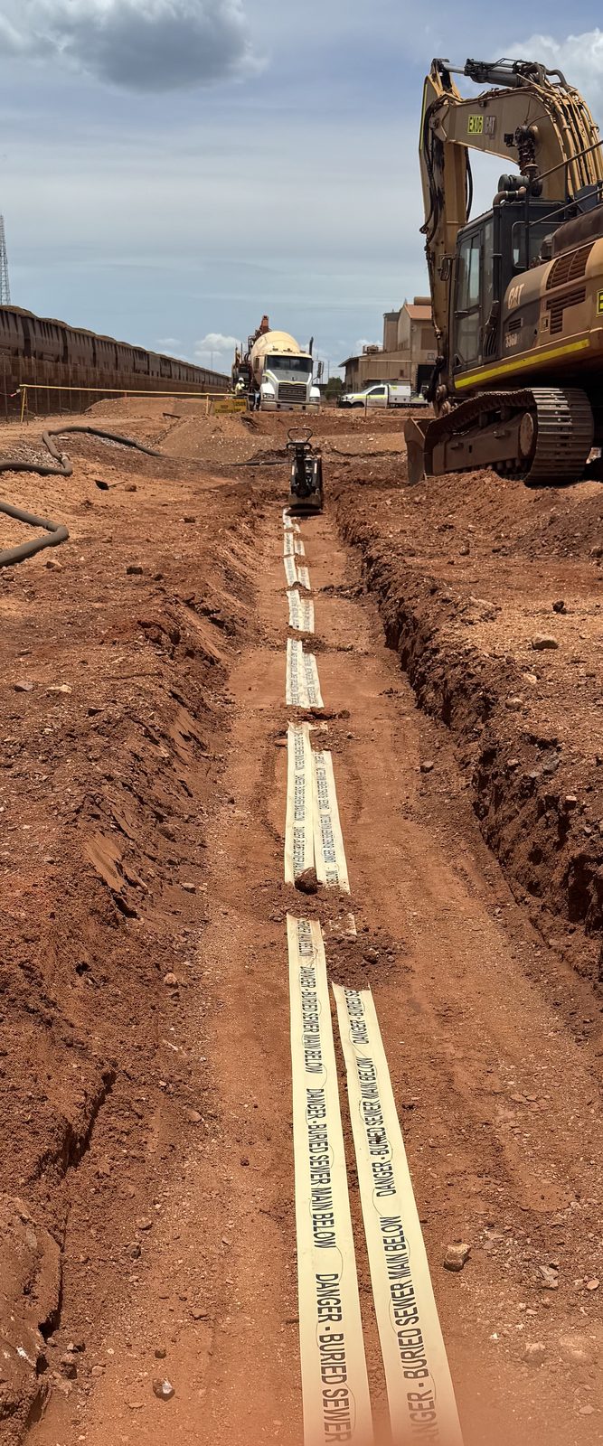 Mine-site service trench with detectable marker tape before backfill